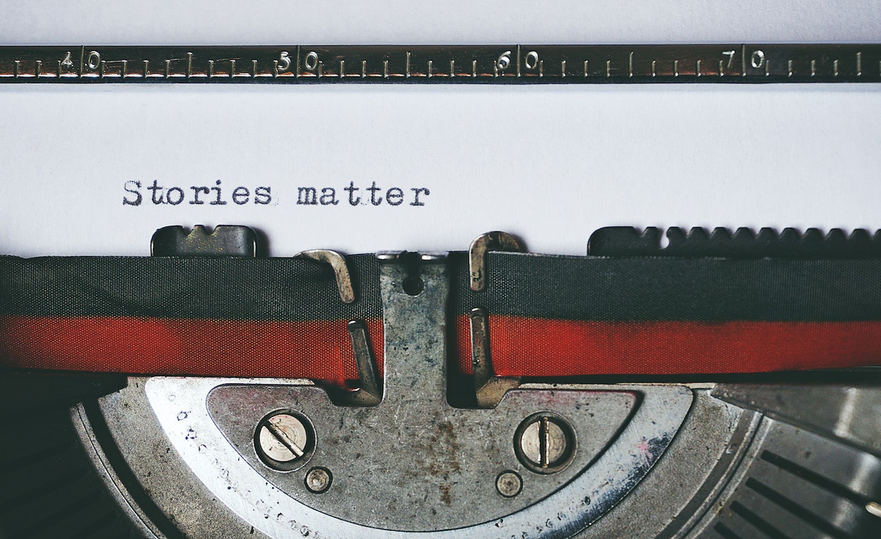 Schreibmaschine mit schwarz-rotem Farbband. Schriftzug: "Stories matter".